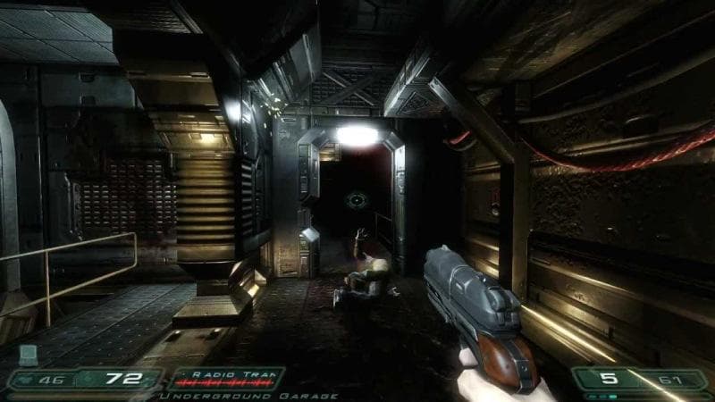 Doom 3 gameplay showing a dark industrial corridor and enemy encounter